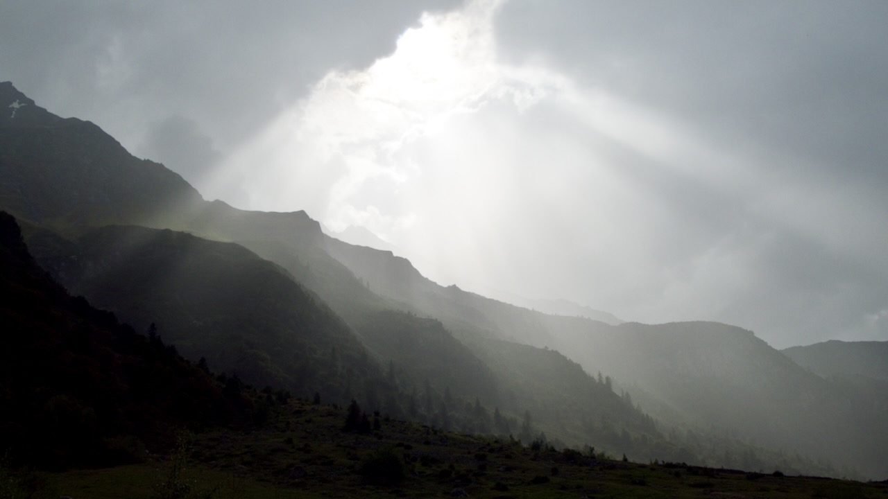 sunlight breaking through clouds over the mountains